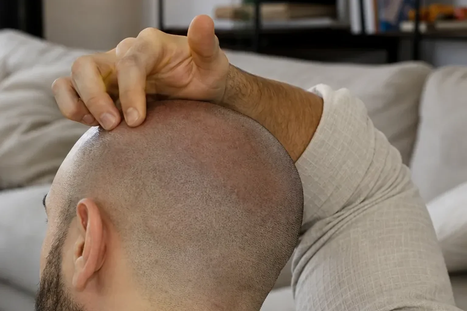 Close view of a man checking his shaved scalp at home during recovery